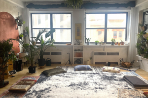Studio space lit by sunlight, with meditation cushions